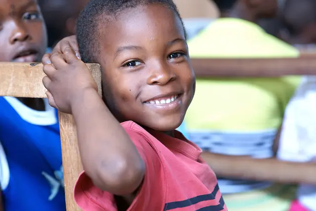 A smiling boy at his school desk